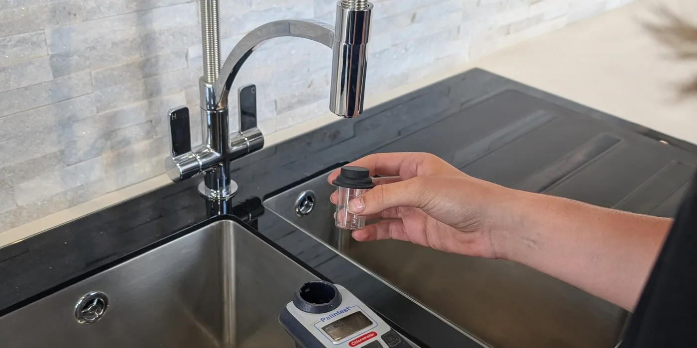 Taking a water sample at an outlet for a chlorine residual check